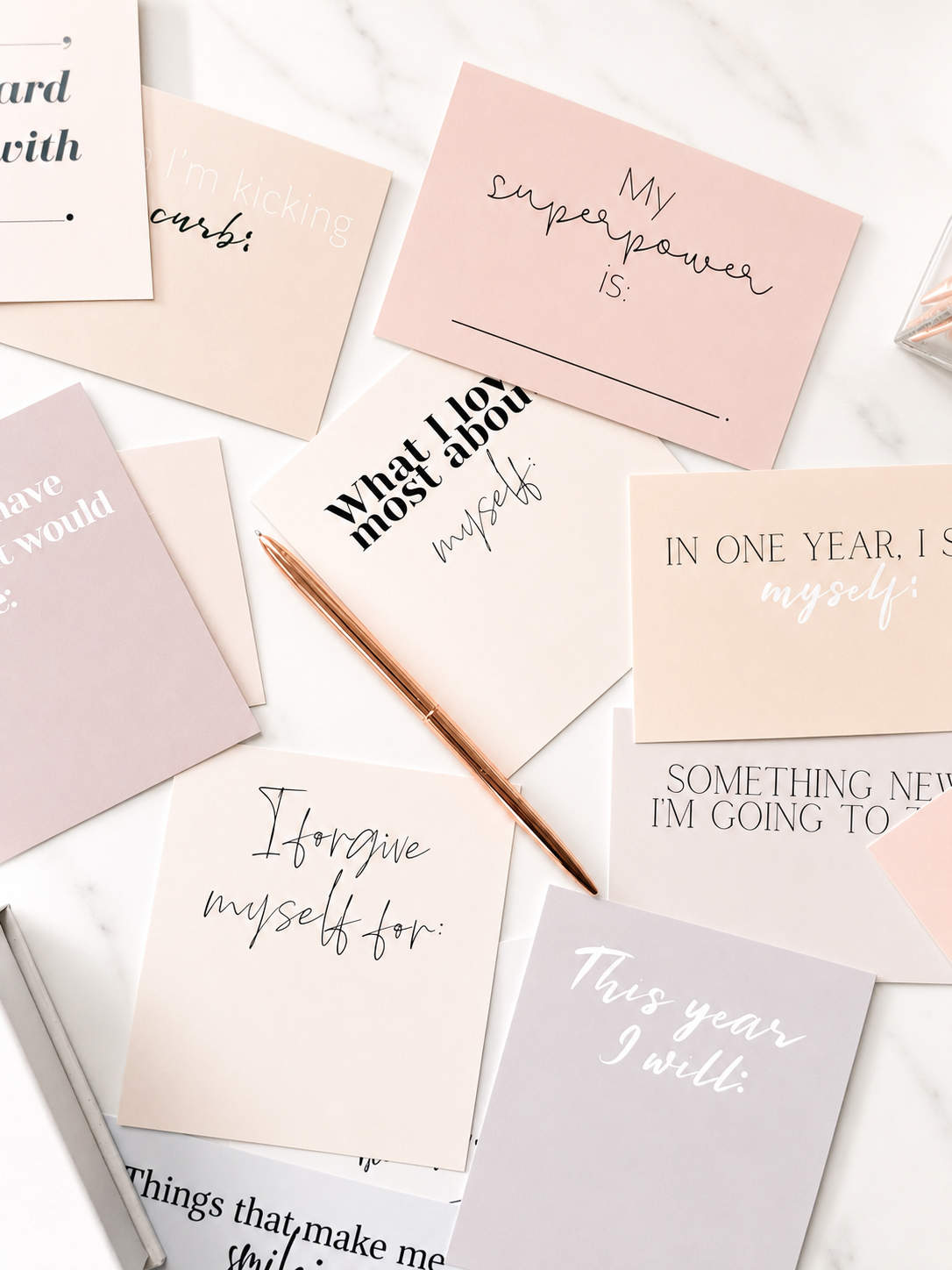 Close-up of assorted pastel affirmation cards with motivational messages in pink and cream tones.