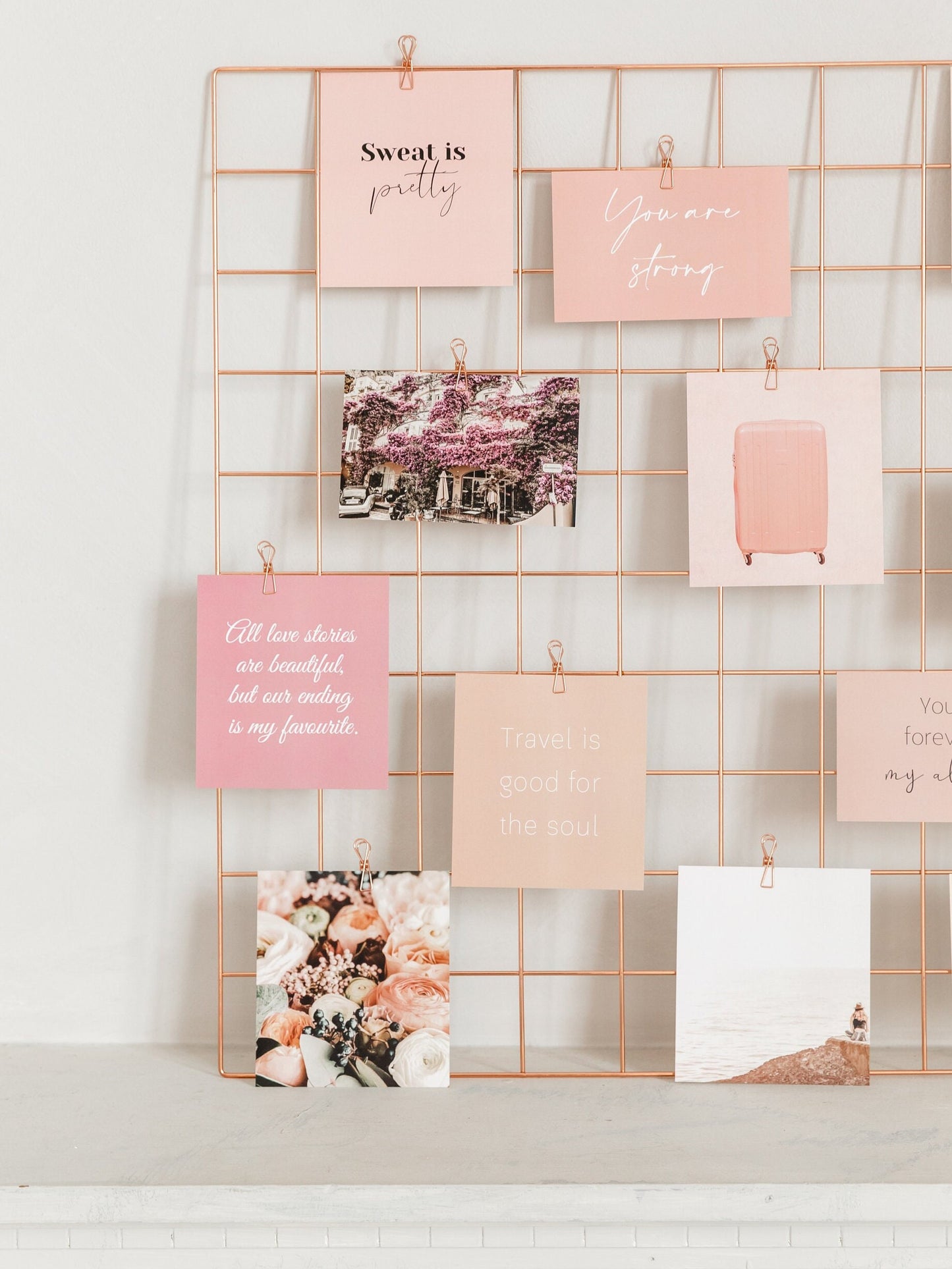 Full wall grid display with rose gold wire clips, cards, and photos