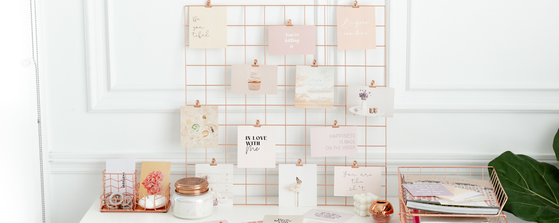 Self-love vision board propped up on a desk with stationary.