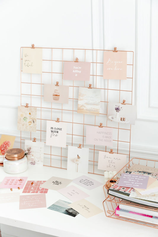 Self0love vision board propped up on a desk with stationary.