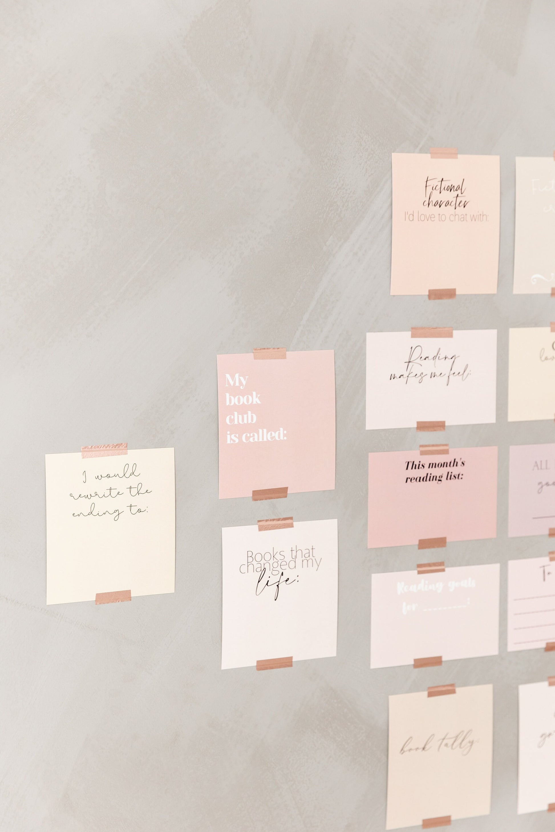 Bookish vision board cards displayed on a wall with soft pink and neutral cards