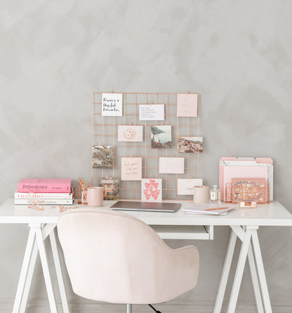 Rose gold wire grid mounted on wall as vision board display
