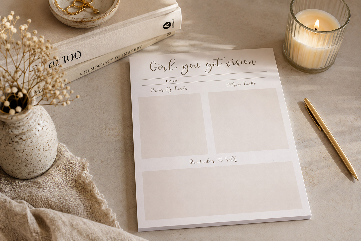 Daily planner notepad on a warm desk with candle, books, and pen