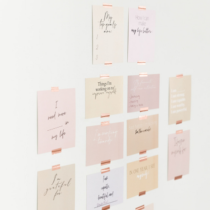 Goal setting vision board cards taped onto wall