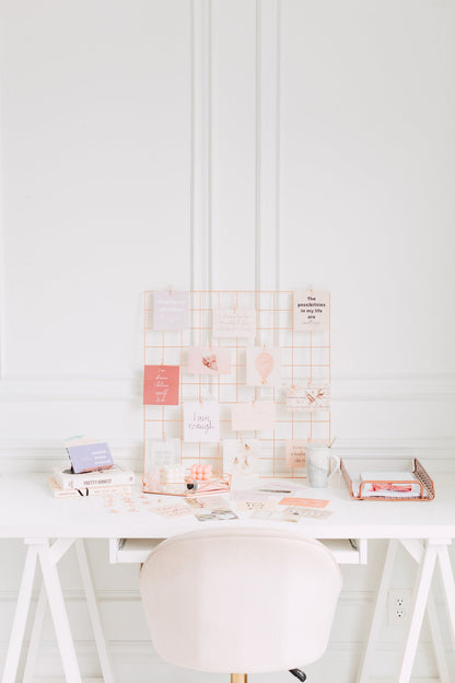 Manifestation vision board cards clipped to a wall grid for daily inspiration