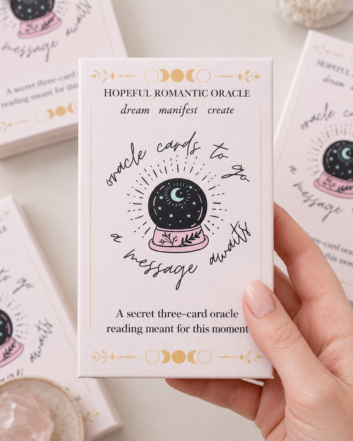 Mini oracle card reading envelope held in hand with soft pastel envelopes in the background
