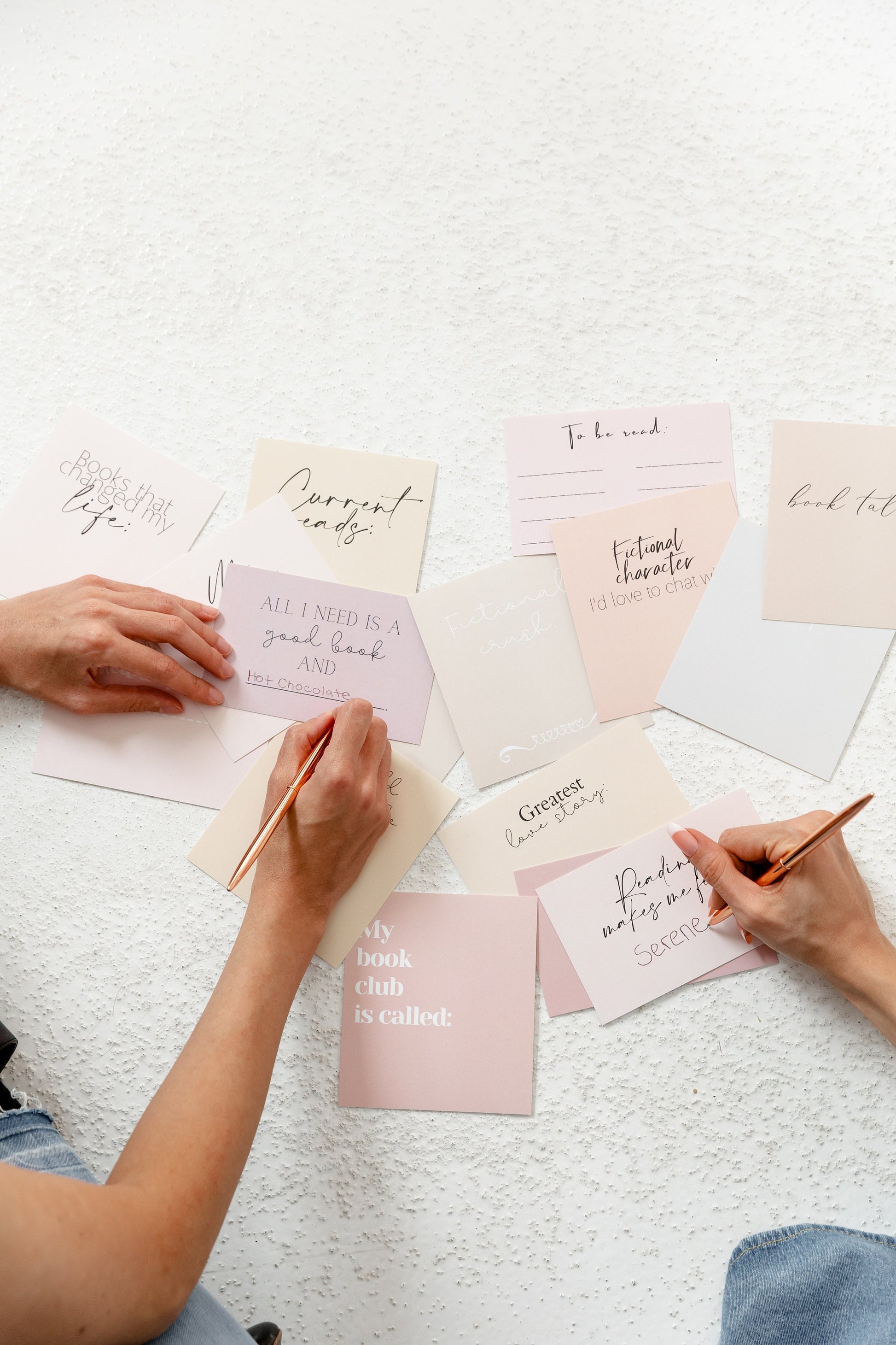 Reading tracker cards styled on a desk with bookish cards and writing tools