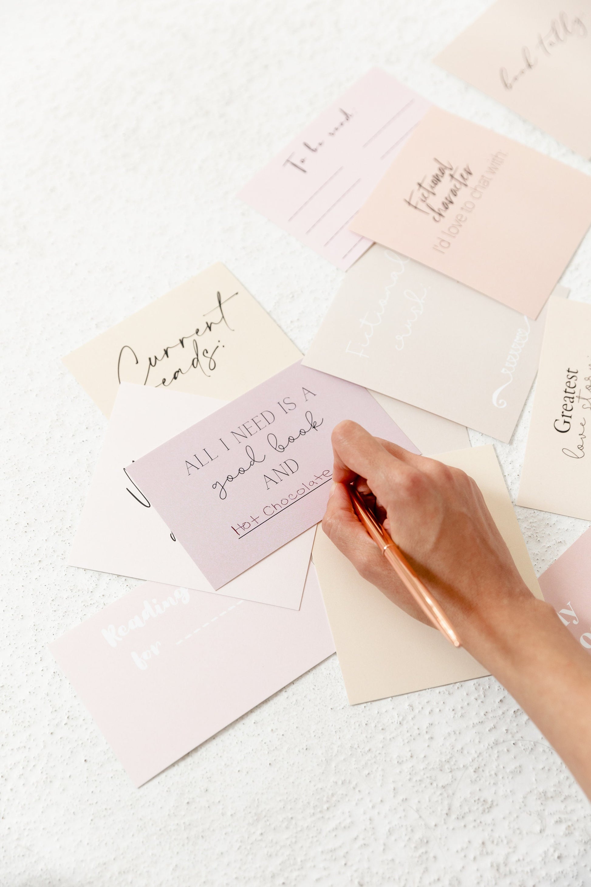 Reading tracker card being filled in with a pen for a monthly reading list