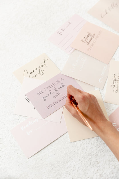 Reading tracker card being filled in with a pen for a monthly reading list
