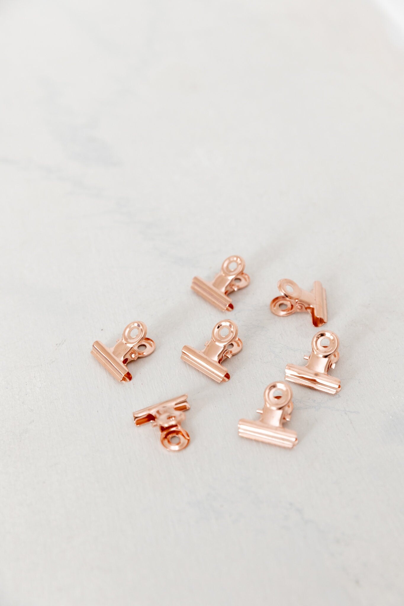 Close-up of 22mm rose gold bulldog clips on a light background