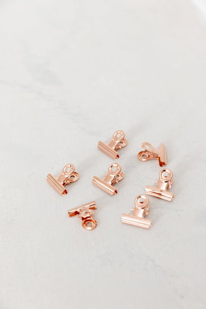 Close-up of 22mm rose gold bulldog clips on a light background