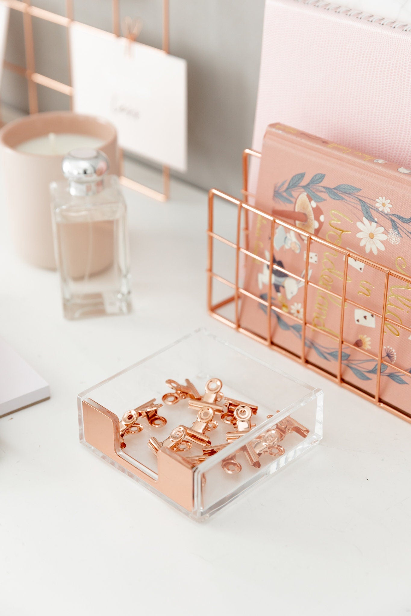 Rose gold bulldog clips styled with a desk organizer, candle, and stationery