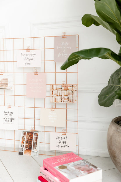Rose gold clips used to display photos, notes, and cards on a mood board
