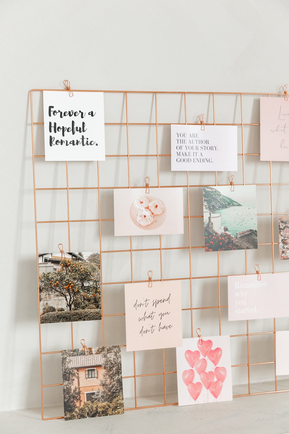 Close-up of rose gold wire vision board grid with clipped quote and image cards