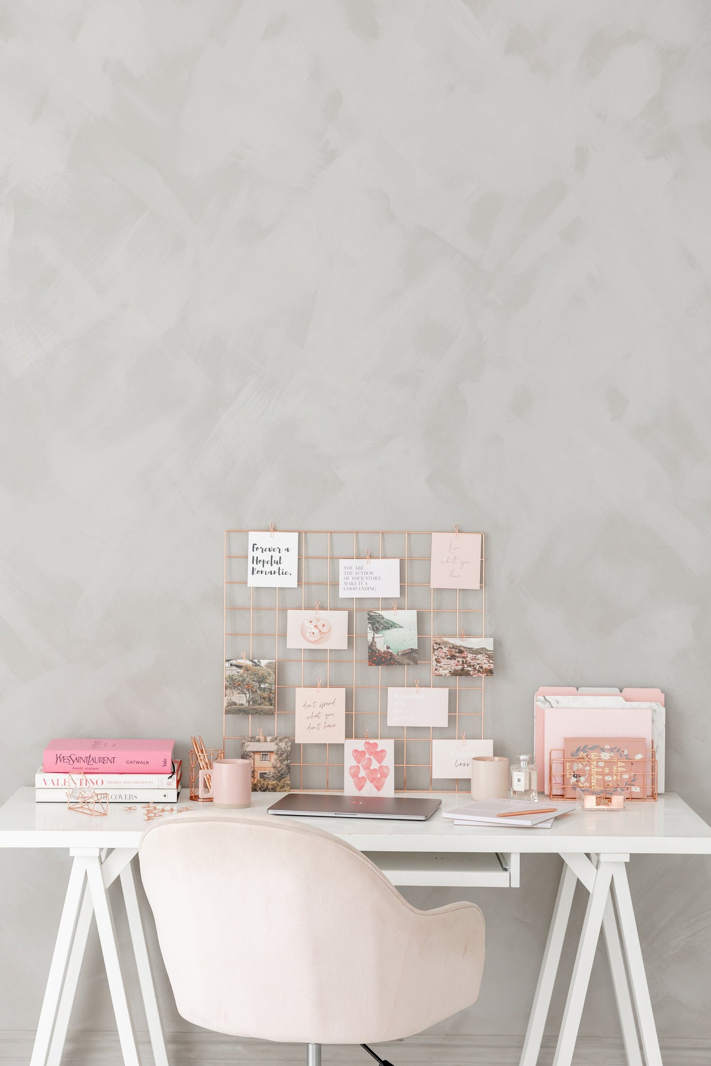 Rose gold wall grid styled on a desk with cards and stationery