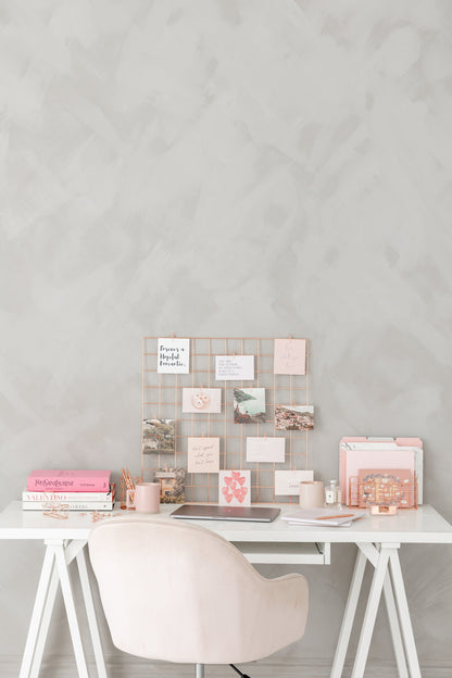 Rose gold wall grid styled on a desk with cards and stationery