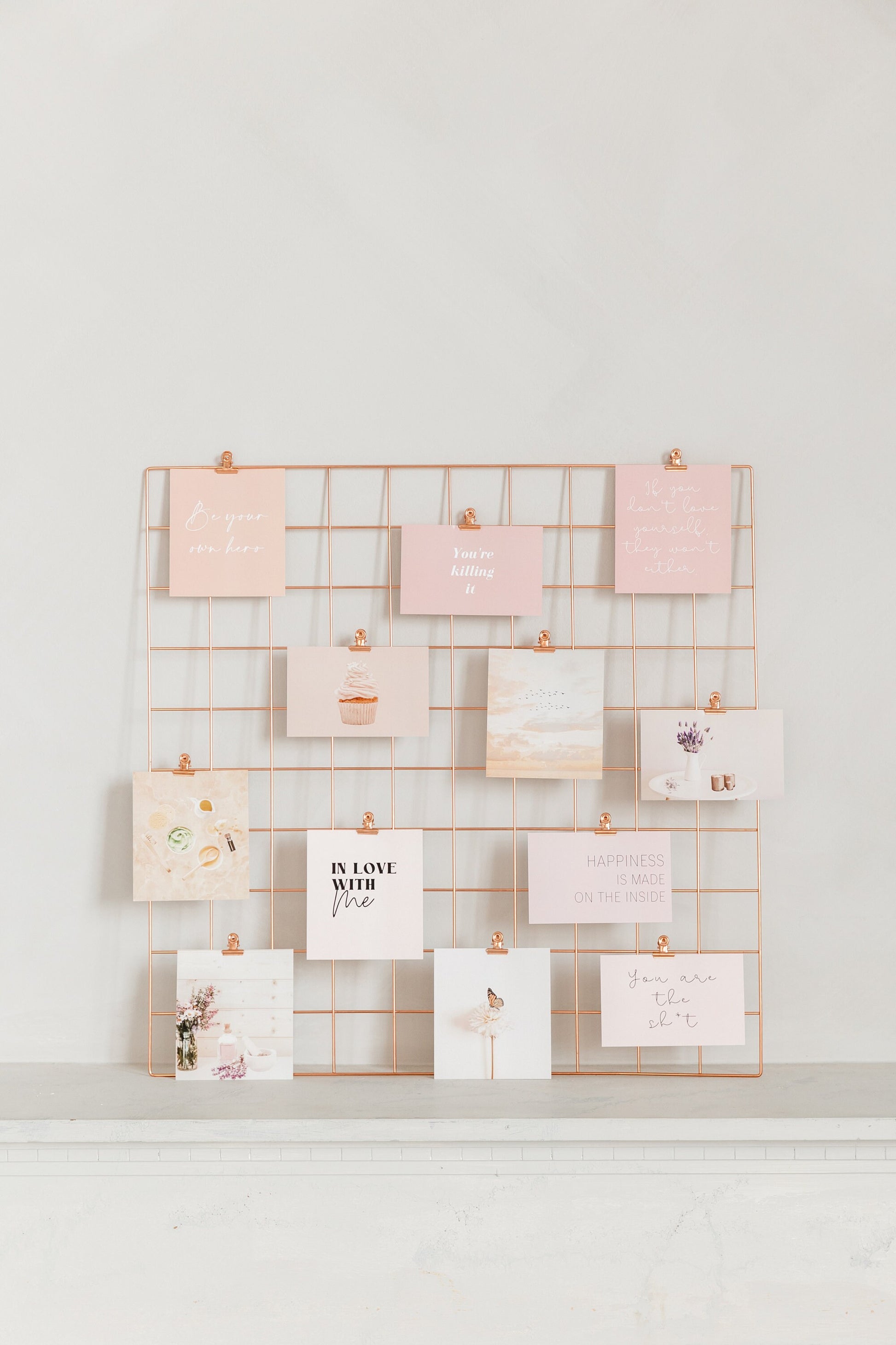 Rose gold wall grid with vision board cards clipped on display