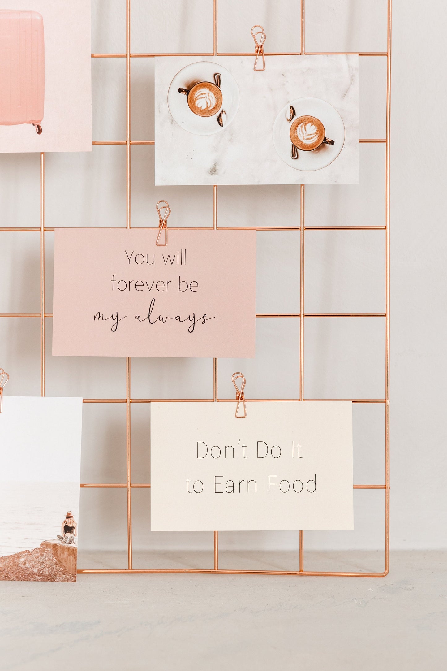 Rose gold wire clips holding cards on a wall grid display