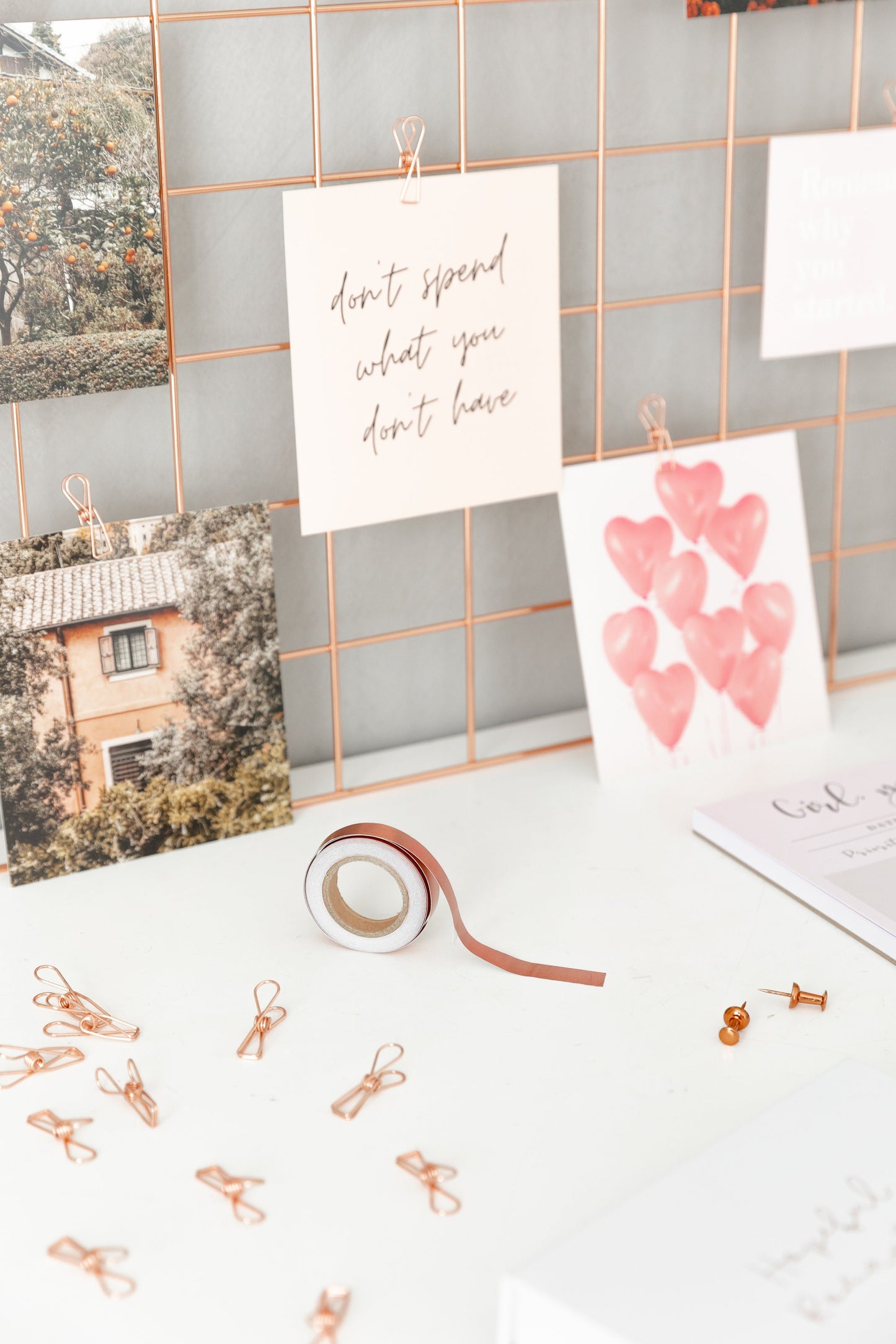 Rose gold wire clips used in a styled desk display with cards and decor