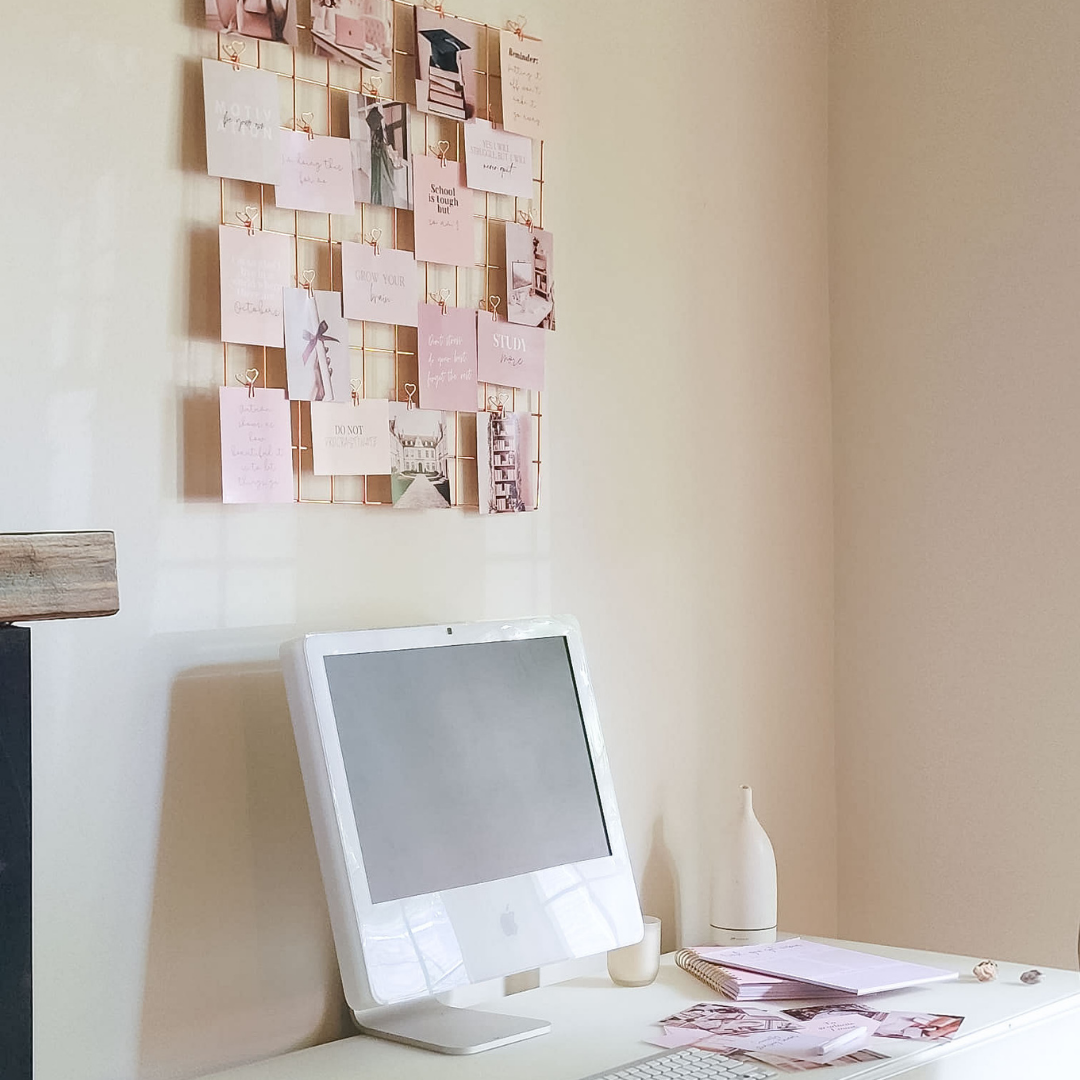 Study vision board mounted above desk in home office with computer setup