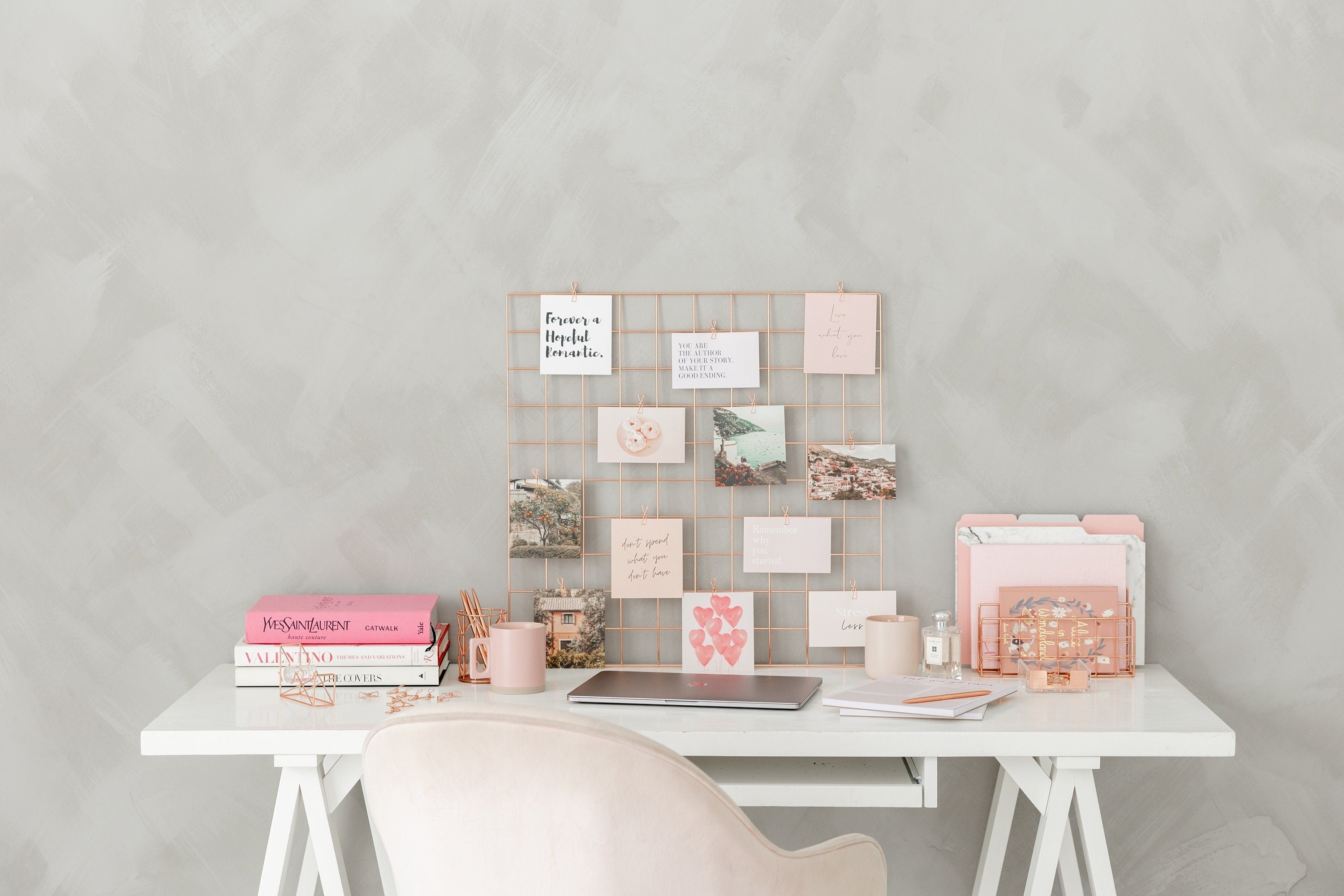 Vision board cards styled on a desk with a rose gold grid and cozy decor