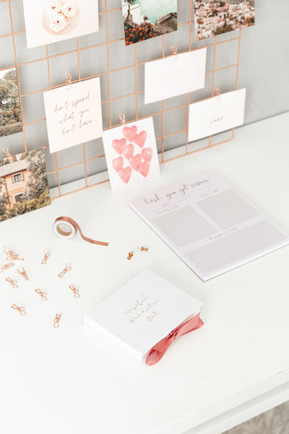Vision board kit displayed on bedroom wall with photos and affirmations