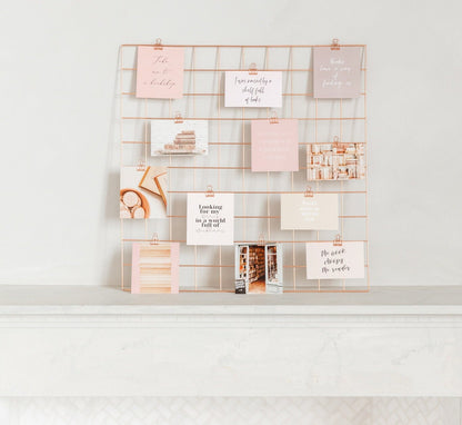 Vision board wall grid styled with rose gold clips and inspiration cards